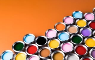 An artistic view of multiple open paint cans containing a variety of paint colors