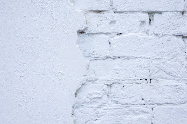 A white brick wall half-finished with stucco