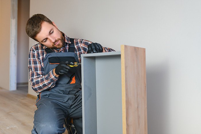 A professional repairs a cabinet drawer