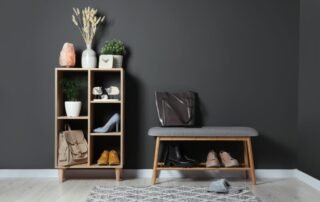 A hallway with dark gray walls and a wooden shelf and bench
