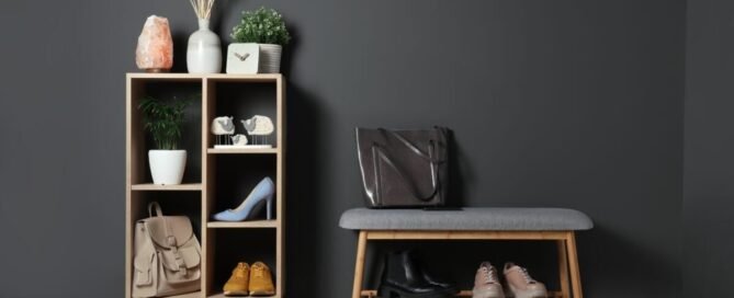 A hallway with dark gray walls and a wooden shelf and bench