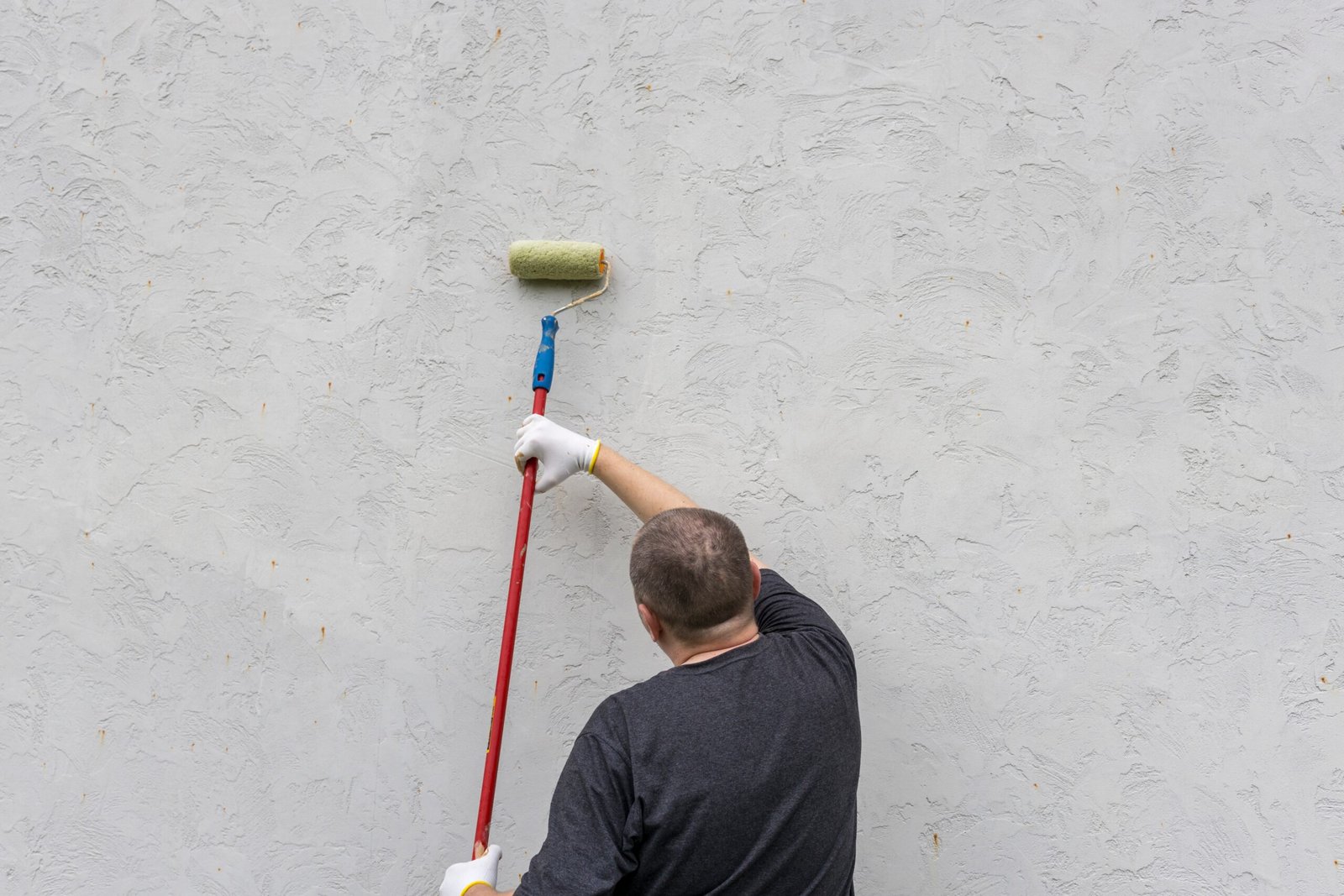 A,Person,Applies,Textured,Paint,To,A,Wall,With,A