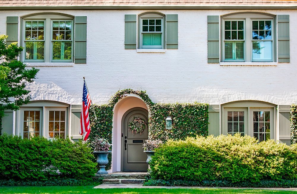 white-painted-brick-house-exterior White brick exterior with green shutters and landscaped front yard
