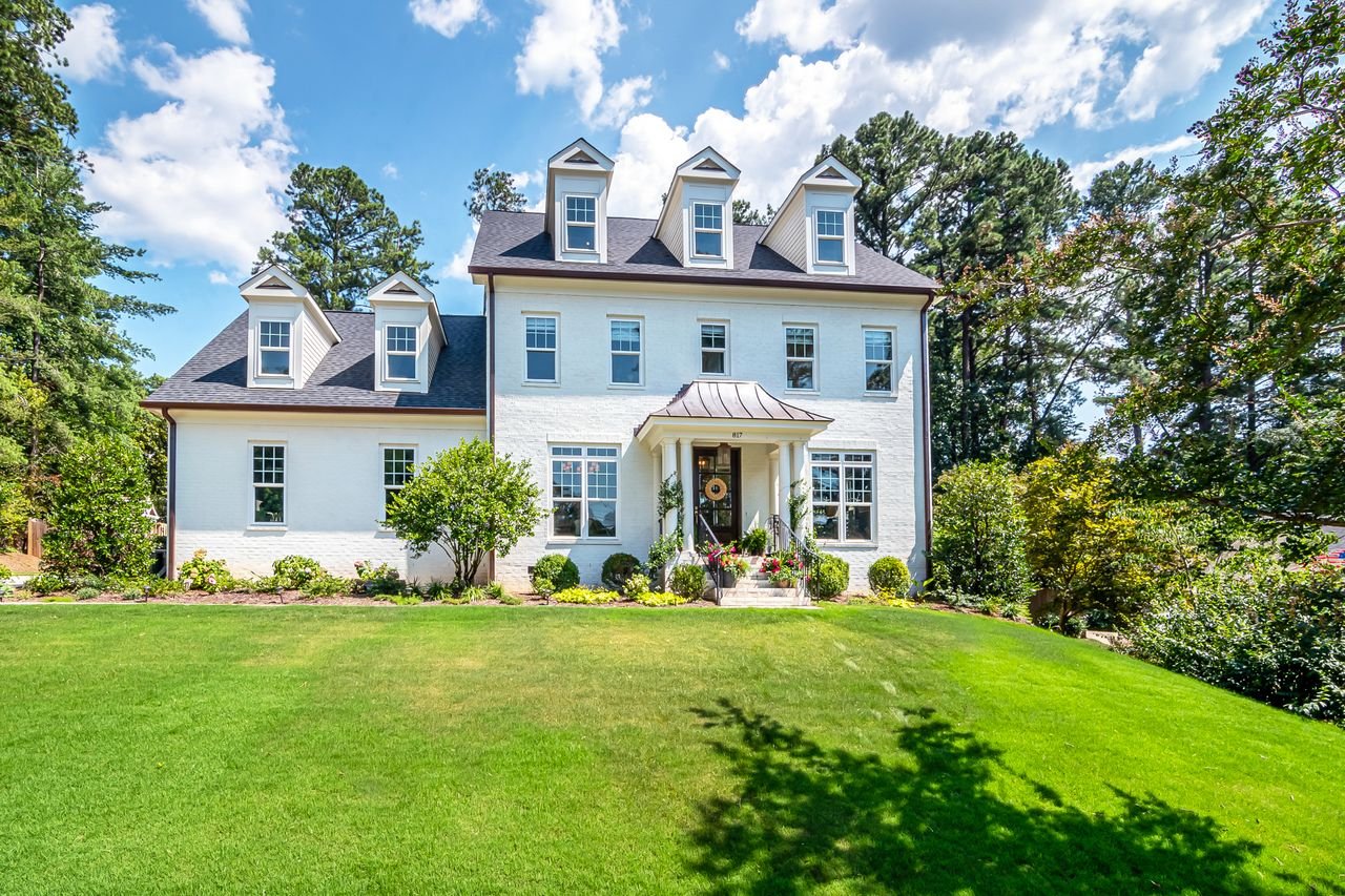 colonial-house-mineral-paint-exterior Colonial-style house with mineral paint facade and lush green lawn