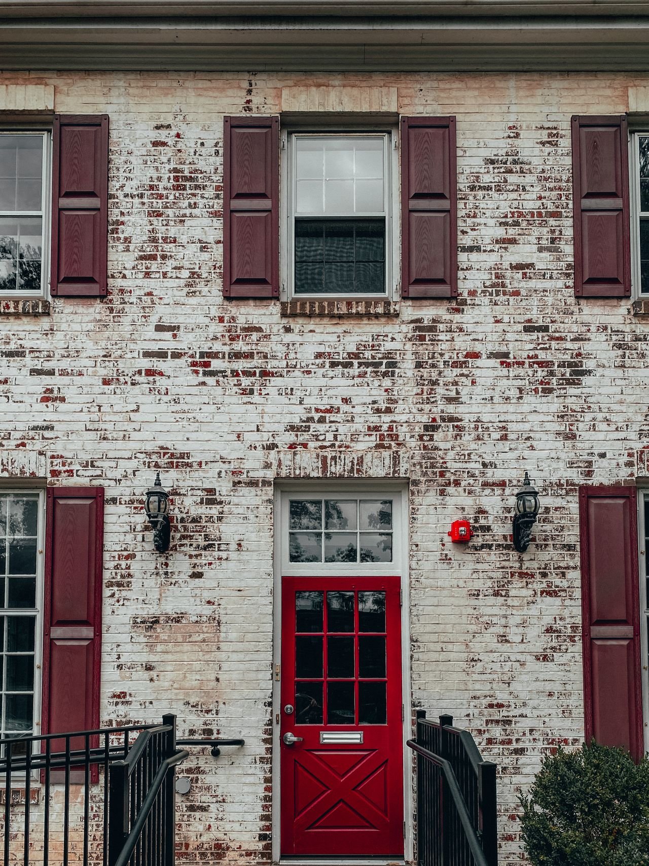 limewash-brick-exterior-red-door Distressed limewash brick house exterior with red door